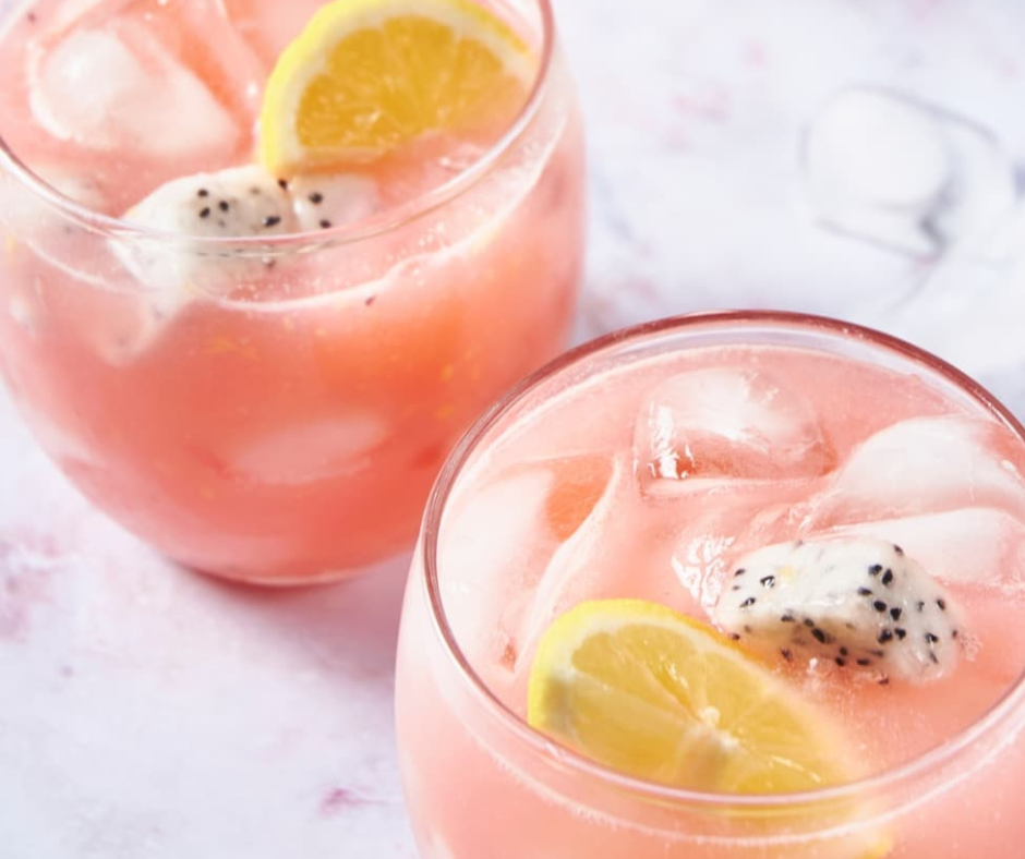 "dragonfruit lemonade in glass with ice, lemon slice and dragonfruit"