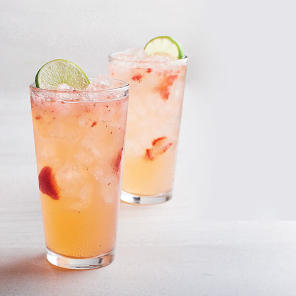 "strawberry mango lemonade with lime slices with ice and strawberries
