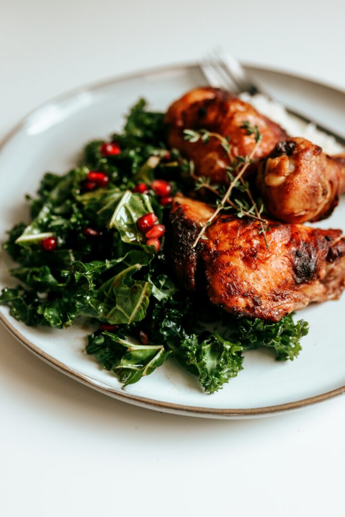 "Roasted Chicken dinner with chicken thighs, legs with greens"