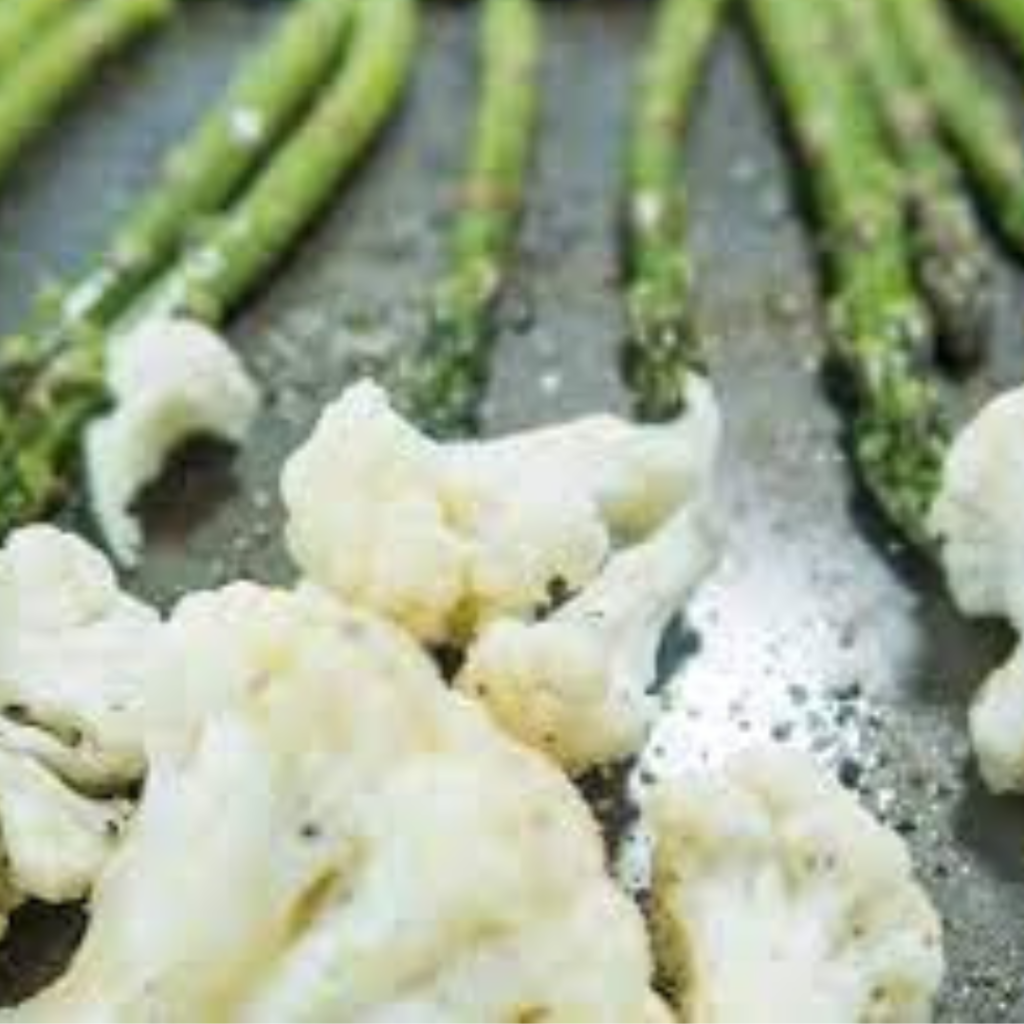 "cauliflower and asparagus on a baking tray"