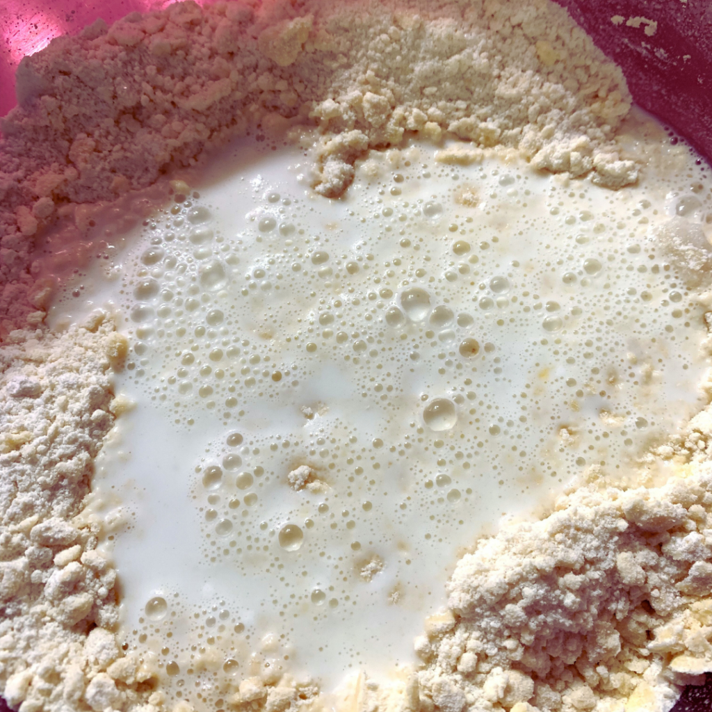 "Johnny cake flour mixture with milk added in a bowl"