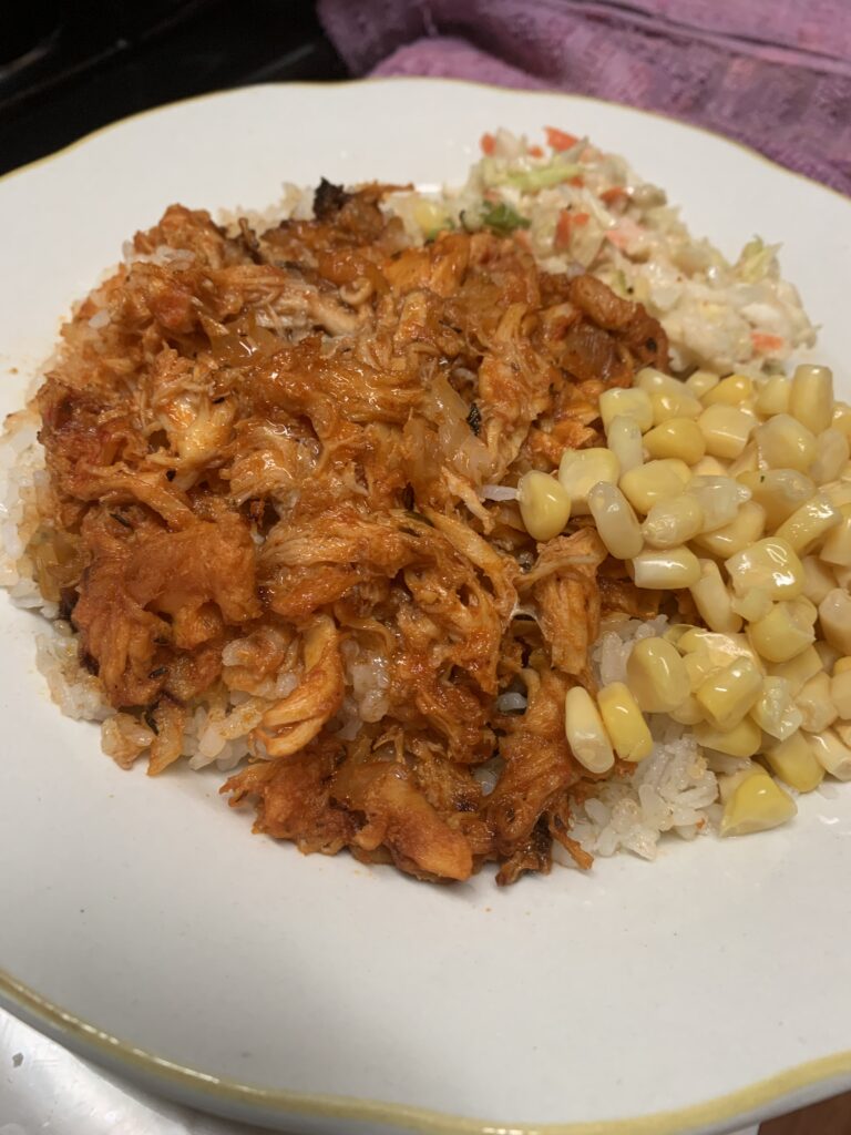 "Minced crawfish, white rice, corn and coleslaw on a white plate"