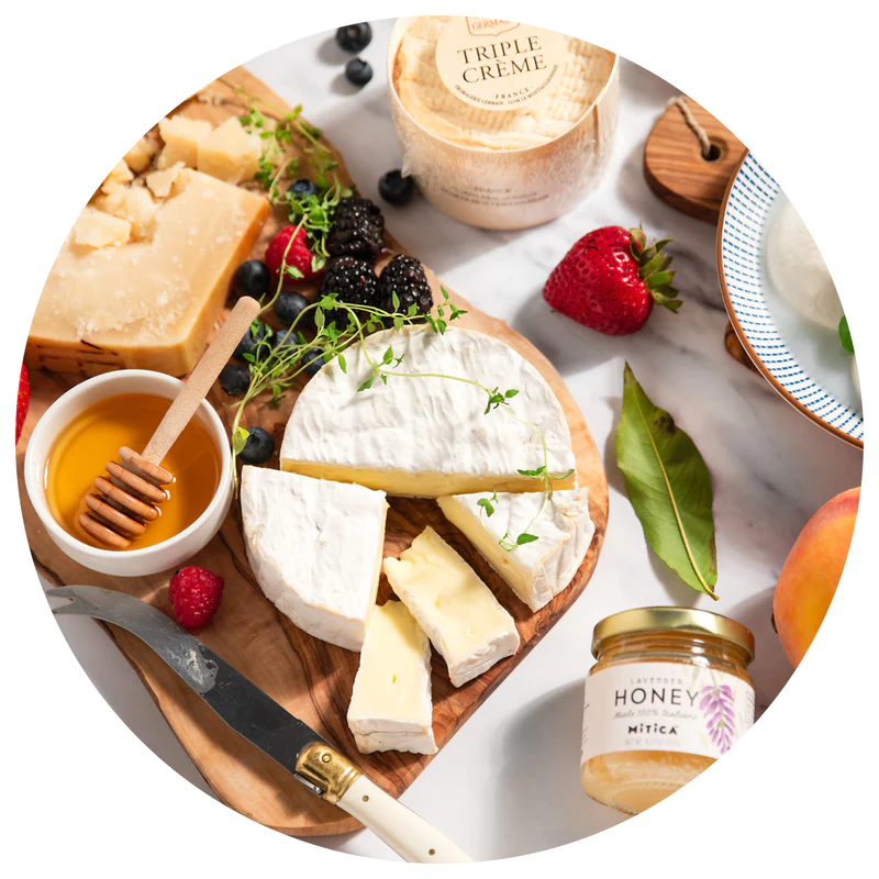 "Cheese, honey, fruits, crackers and herbs on a white background"