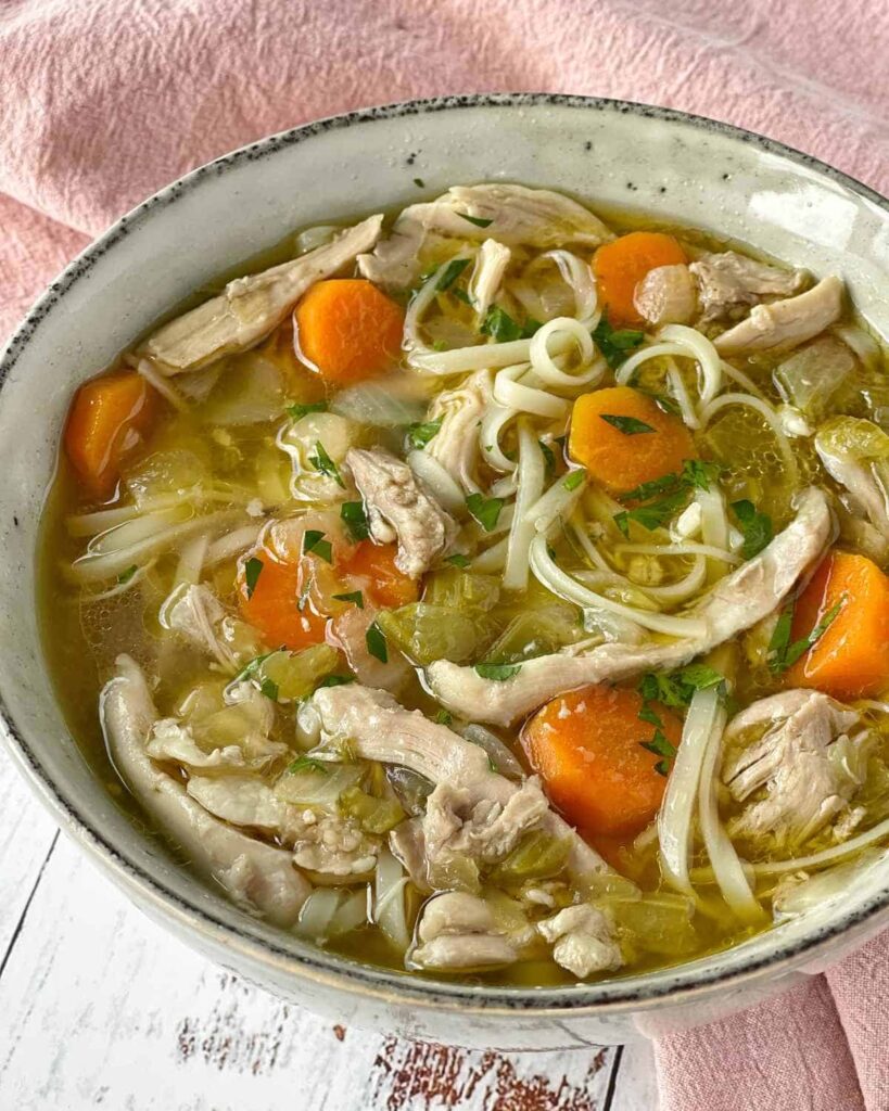 "Chicken Noodle Sop with cabbage and carrots in a chicken broth"