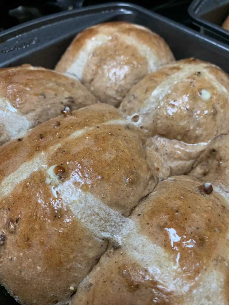 Hot Cross buns fresh out the oven being cooled in baking pans"