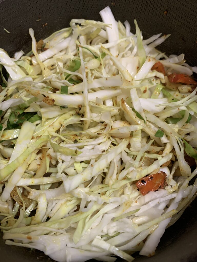 "vegetables sauteeing with cabbage in a pot"