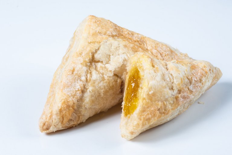 "Triangle shape pastry filled with mango and pineapple filling on a white background"