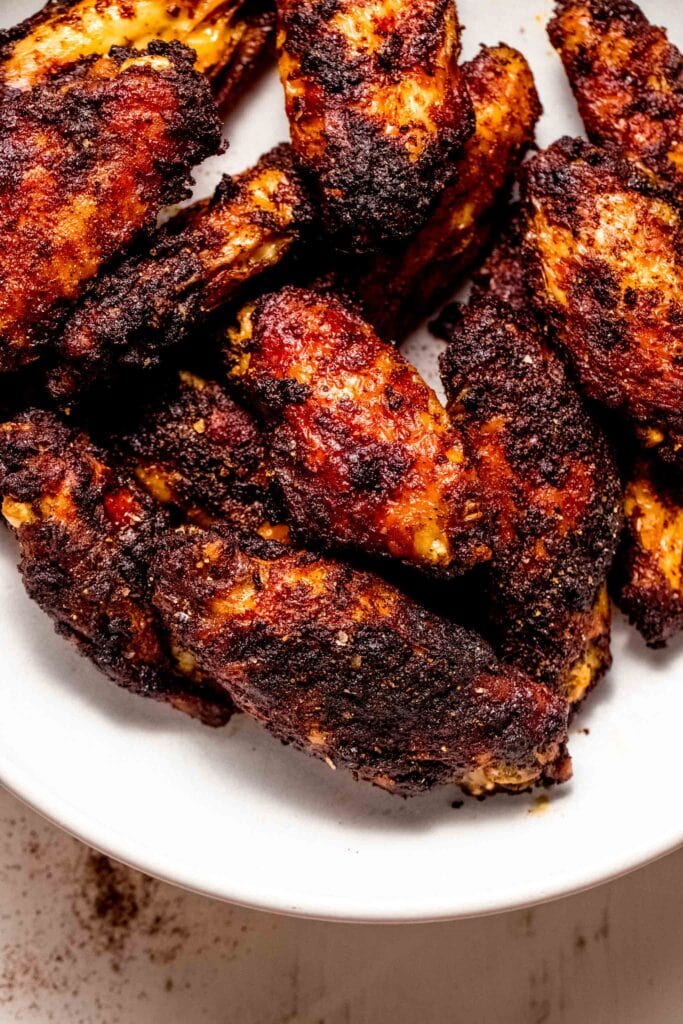 "Heavily spiced chicken wing pieces cooked and ready to eat on a plate