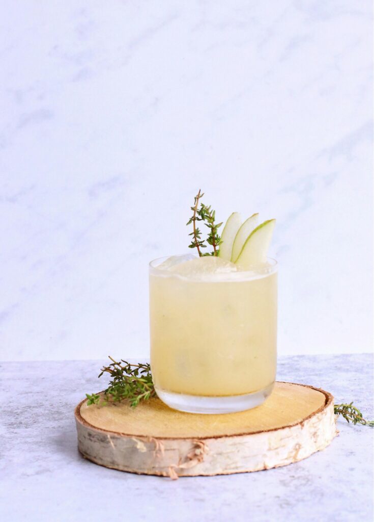 A drink on a wood bark with a white backdrop on a marble tile background"