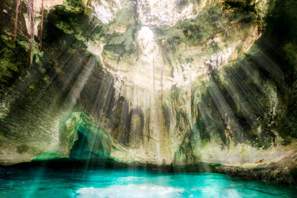 ""Enclosed cave in the ocean with sunlight streaming through opening"