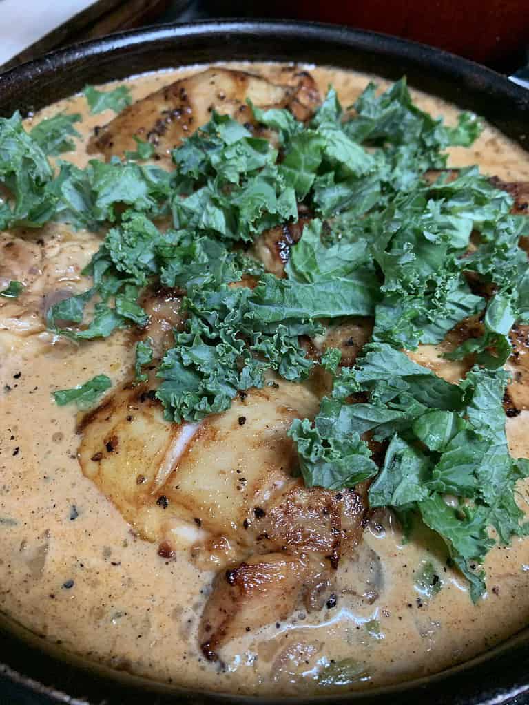 Chicken thighs in a creamy broth with kale added
