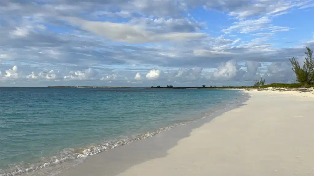 a beach with a body of water and clouds