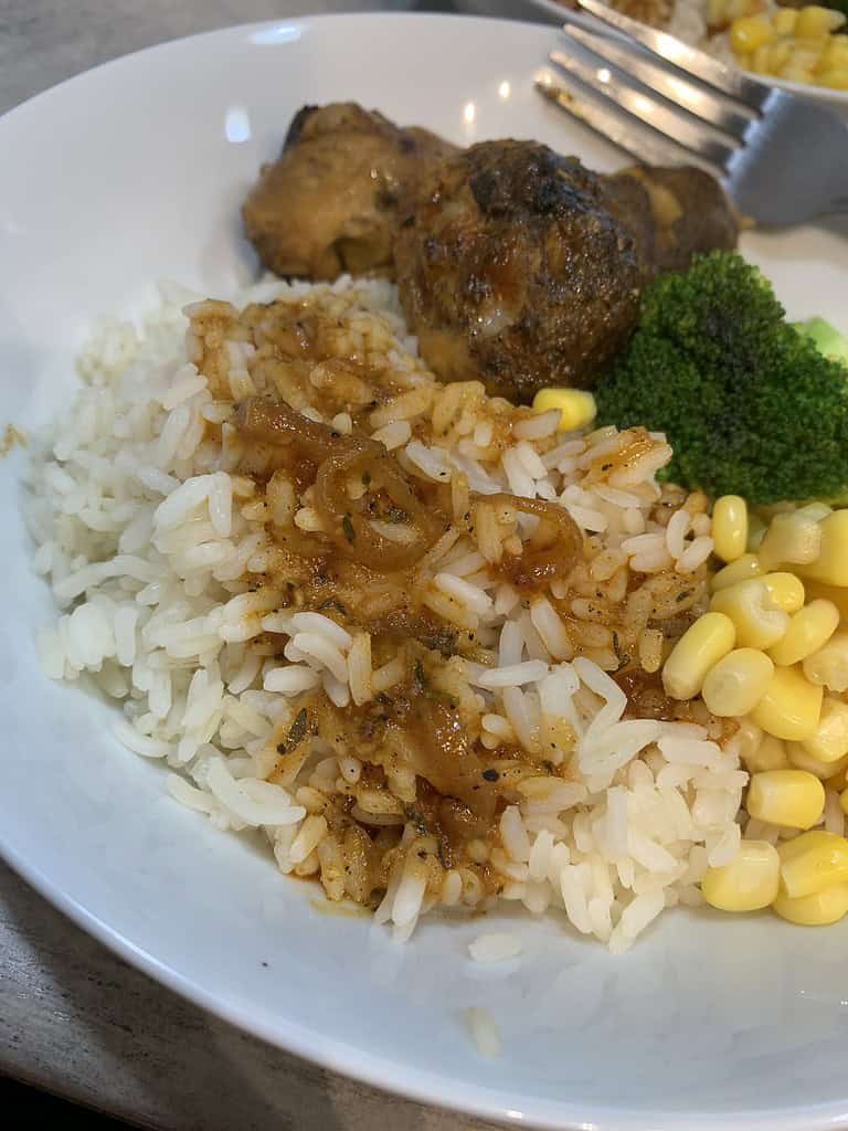 Rice, chicken, corn with gravy on a plate
