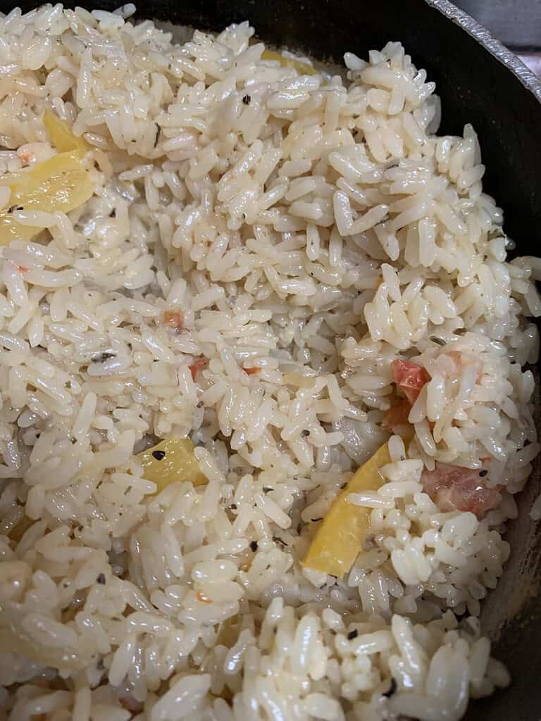 Cooked rice in a pot with yellow bell peppers
