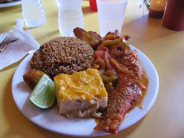 Bahamian steamed fish dinner with macaroni, peas and rice