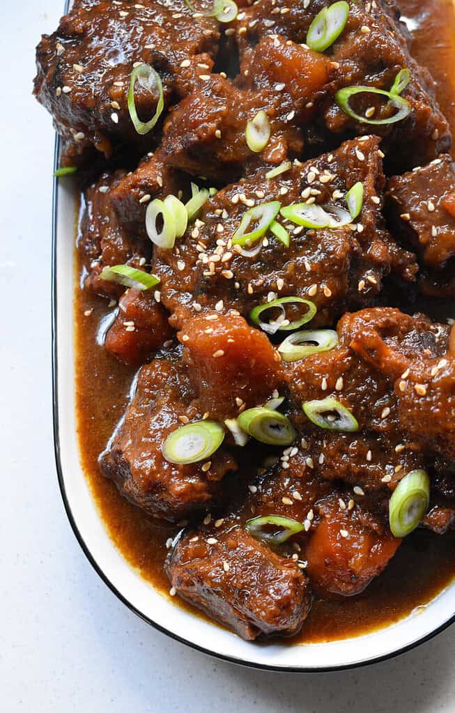 Braised meat in a dish with vegetables and green onion