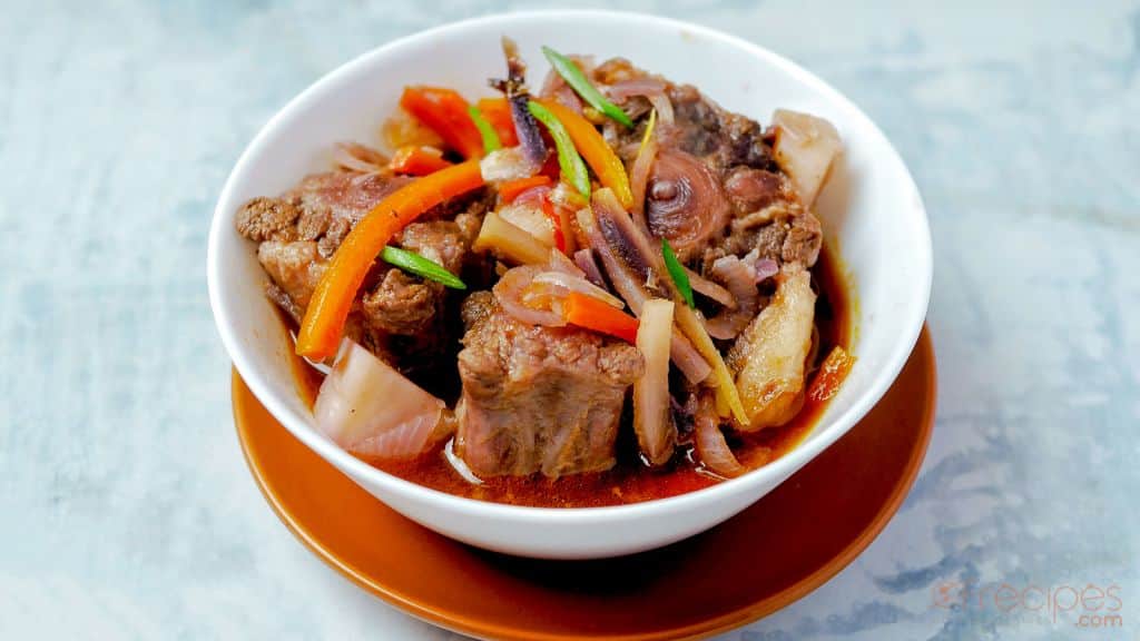 oxtails with vegetables, a little broth in a white bowl