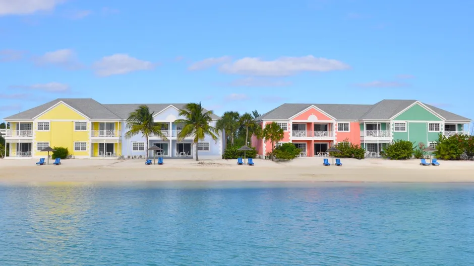 Brightly colored buildings with sand a beach in the background