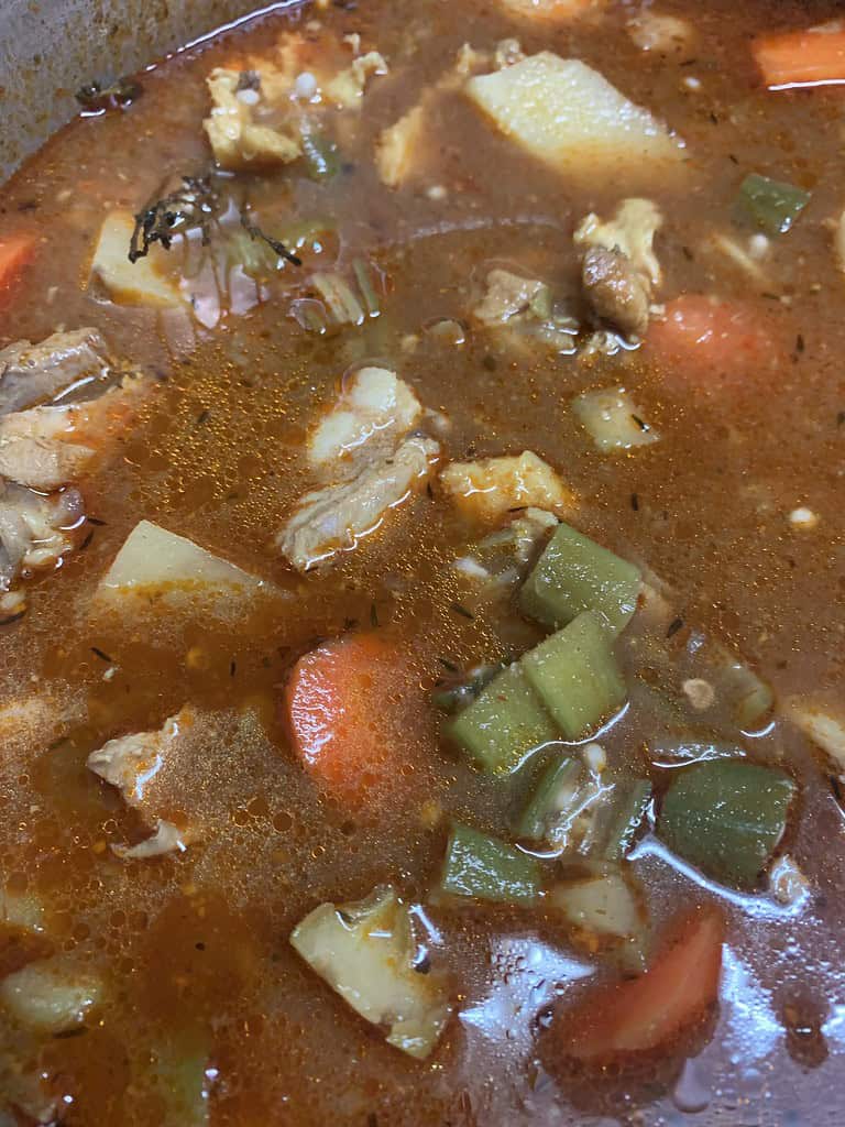 a pot of soup with vegetables and meat