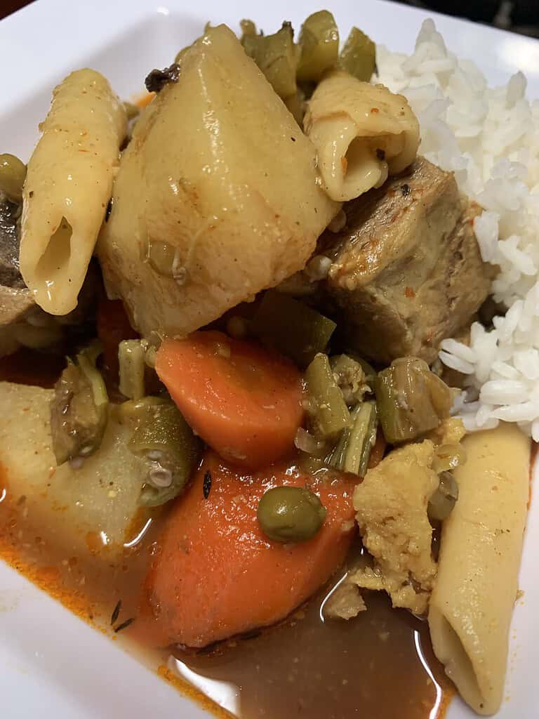 A bowl of soup that has potatoes, carrots, and okra served with barefoot Rice