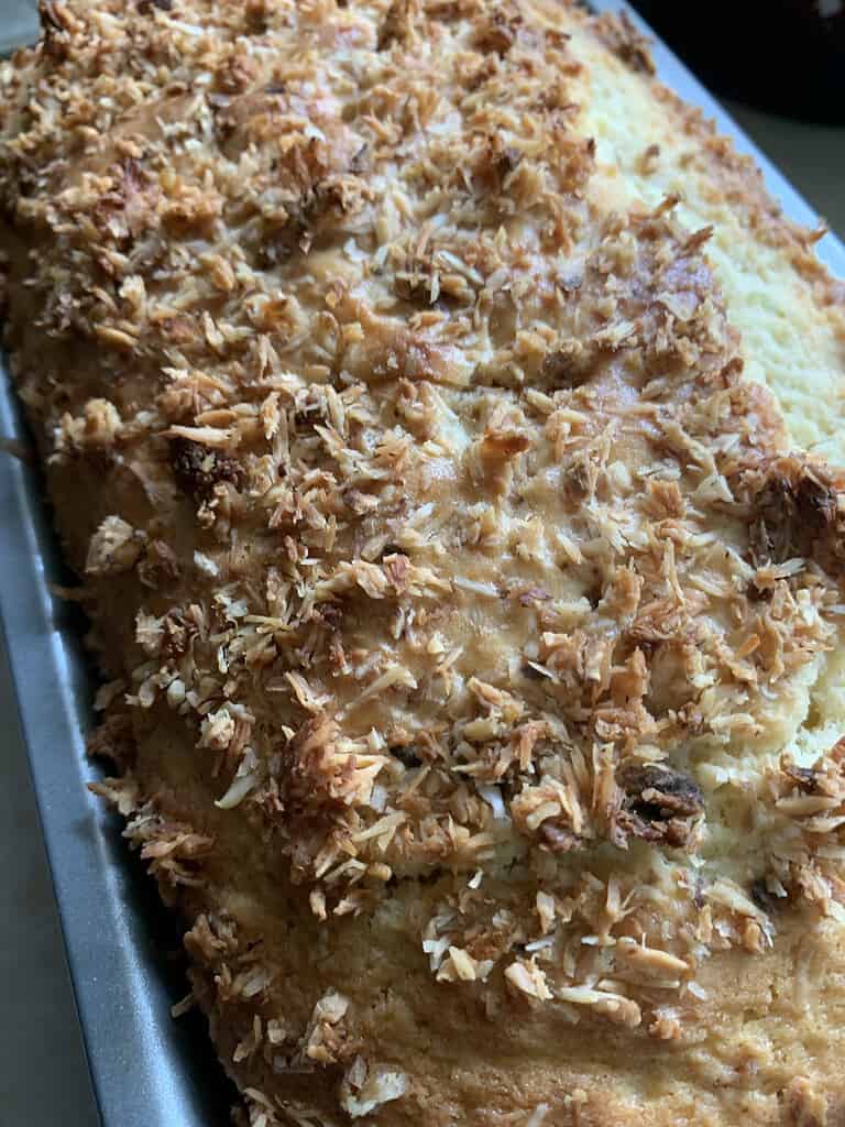 Cake top with shredded coconut in a loaf pan