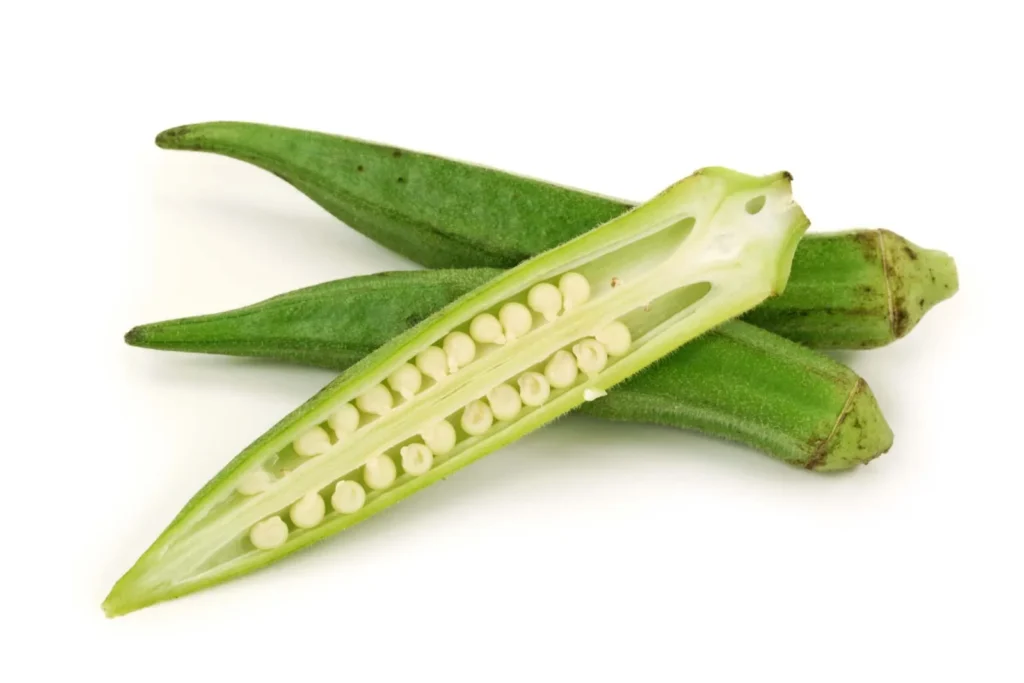 The okra vegetable cut in half on a white. background