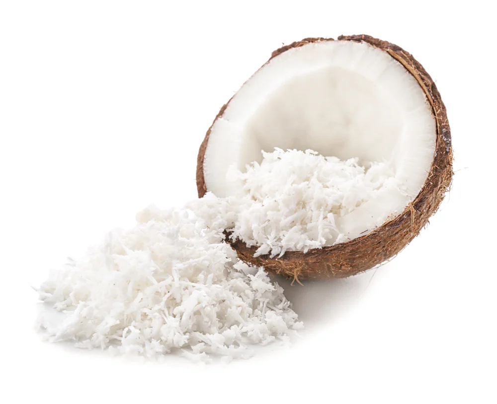 shredded coconut in a coconut with brown shell on white background