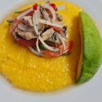 "Sardine and Grits with a slice of avocado"