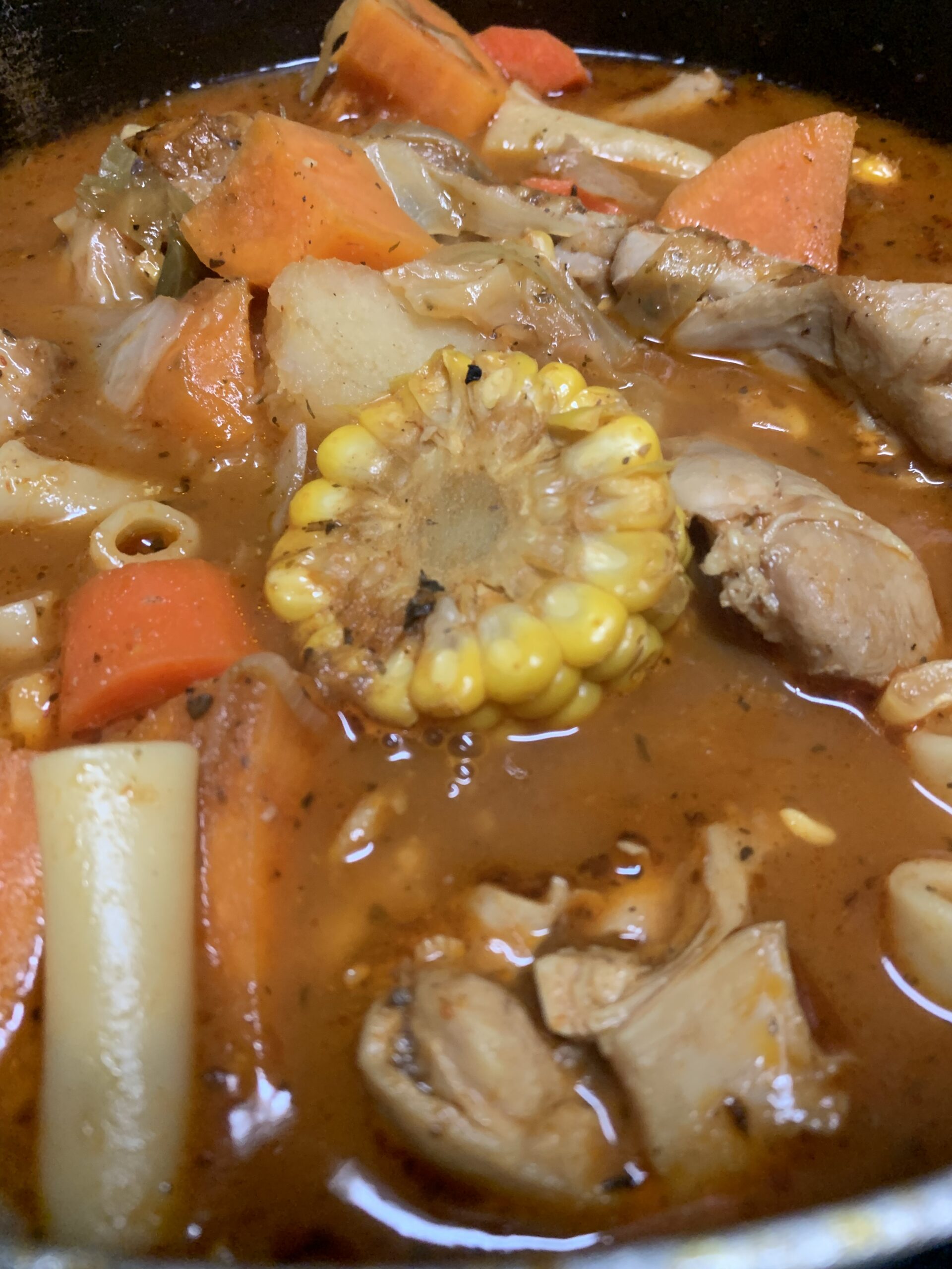 "Simple Chicken Drumstick Soup Recipe, in a pot with noodles, carrots, sweet potato, chicken, potatoes and corn"